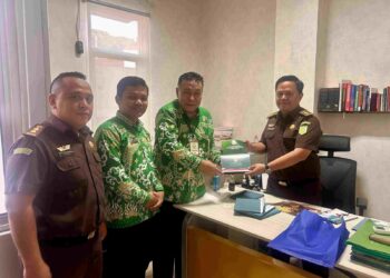 Wakil Ketua DPW LDII Provinsi Lampung, Heri Sensustadi (kiri), menyerahkan buku himpunan hasil Musyawarah Wilayah (Muswil) VIII LDII Lampung kepada Jaksa Ahli Madya Gilar Suryaningtyas (kanan) saat kunjungan silaturahim di Kantor Kejati Lampung, Selasa (30/12). Foto: Dok. LINES Lampung