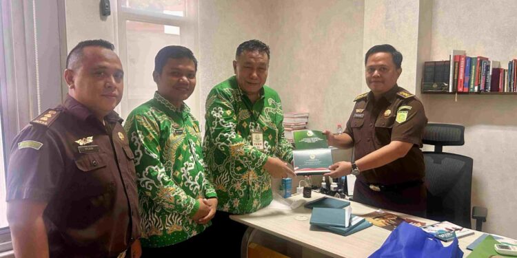 Wakil Ketua DPW LDII Provinsi Lampung, Heri Sensustadi (kiri), menyerahkan buku himpunan hasil Musyawarah Wilayah (Muswil) VIII LDII Lampung kepada Jaksa Ahli Madya Gilar Suryaningtyas (kanan) saat kunjungan silaturahim di Kantor Kejati Lampung, Selasa (30/12). Foto: Dok. LINES Lampung