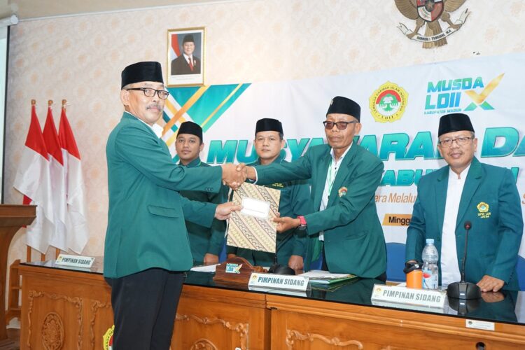 Ketua DPD LDII Kabupaten Madiun Giyanto menyerahkan dokumen laporan pertanggungjawaban masa bakti 20202025 kepada pimpinan rapat paripurna Musda X LDII Kabupaten Madiun di Gedung Diklat Pemkab Madiun Minggu 2112 Foto Dok LINES Madiun