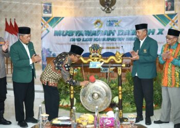 Asisten I Bidang Pemerintahan dan Kesejahteraan Rakyat (Kesra) Setda Kabupaten Madiun, Sujiono, memukul gong sebagai tanda dibukanya Musyawarah Daerah (Musda) X LDII Kabupaten Madiun di Gedung Diklat Pemerintah Kabupaten Madiun, Minggu (21/12). Foto: Dok. LINES Madiun