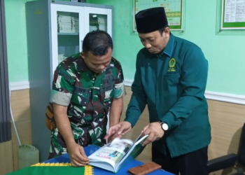 Ketua DPD LDII Jember Akhmad Malik Afandi (kanan) menunjukkan buku program LDII kepada Pasiter Kodim 0824 Jember Lettu Inf Catur Purnomo Hadi (kiri) saat silaturahmi di Makodim 0824 Jember, Jumat (9/1). Salah satu materi dalam buku tersebut membahas wawasan kebangsaan. Foto: Dok. LINES Jember