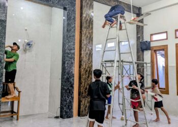 Warga LDII bergotong royong membersihkan bagian dalam Masjid Al-Khasan, Kebalandono, Selasa (17/2), Foto: LINES Lamongan