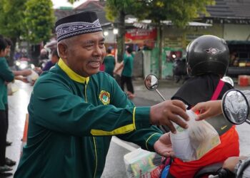 Ketua DPD LDII Ngawi H Yadi membagikan takjil kepada pengguna jalan dalam kegiatan berbagi takjil bersama Pemuda LDII di Ngawi, Kamis (5/3/2026). Foto: LINES Ngawi