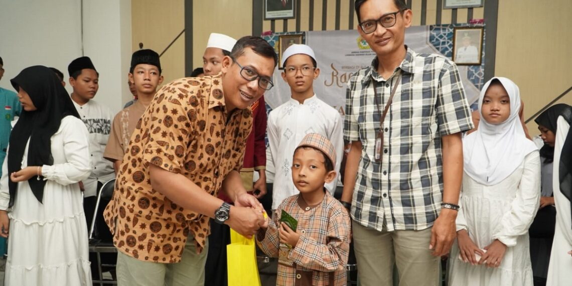 Ketua Departemen Komunikasi Informasi dan Media KIM DPP LDII Ludhy Cahyana menyerahkan santunan kepada anak yatim didampingi Camat Gunung Anyar Indra Fajar Swasana Foto LINES Jatim