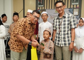 Ketua Departemen Komunikasi, Informasi, dan Media (KIM) DPP LDII Ludhy Cahyana menyerahkan santunan kepada anak yatim didampingi Camat Gunung Anyar Indra Fajar Swasana. Foto: LINES Jatim