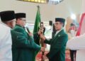 Ketua DPD LDII Banyuwangi masa bakti 20262031 Heri Sujatmiko menerima panji organisasi LDII dalam prosesi penetapan kepemimpinan Foto LINES Banyuwangi
