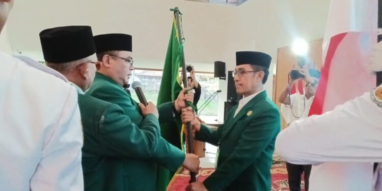 Ketua DPD LDII Banyuwangi masa bakti 20262031 Heri Sujatmiko menerima panji organisasi LDII dalam prosesi penetapan kepemimpinan Foto LINES Banyuwangi
