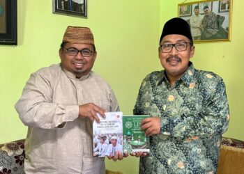Dwi Pramono menyerahkan dua buku tentang nilai kebajikan dan sistem pendidikan LDII kepada KH Ahmad Fahrur Rozi Foto LINES Malang