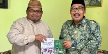 Dwi Pramono menyerahkan dua buku tentang nilai kebajikan dan sistem pendidikan LDII kepada KH Ahmad Fahrur Rozi Foto LINES Malang
