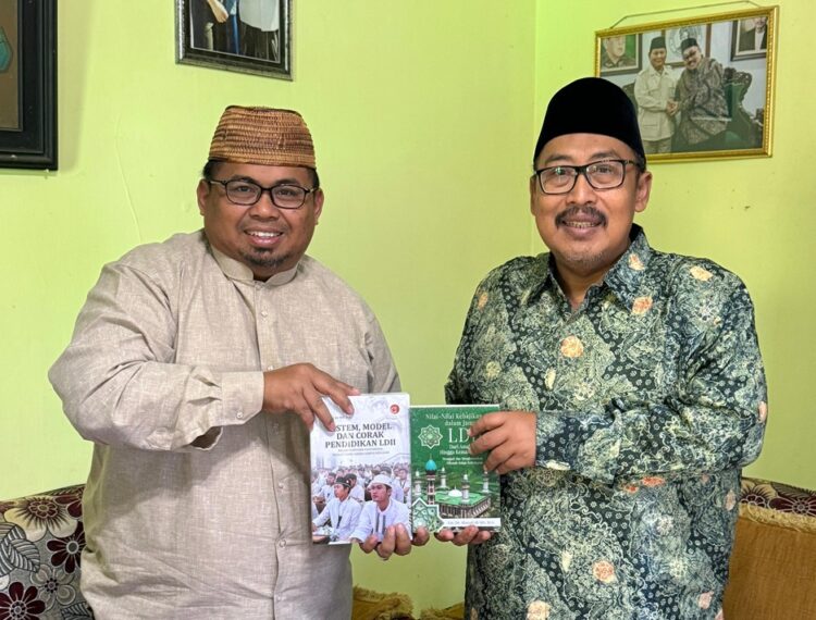Dwi Pramono menyerahkan dua buku tentang nilai kebajikan dan sistem pendidikan LDII kepada KH Ahmad Fahrur Rozi Foto LINES Malang
