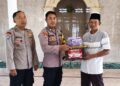Personel Polri menyerahkan bantuan sosial berupa mushaf Al-Qur'an dan perlengkapan kebersihan. Foto: LINES Banyuwangi