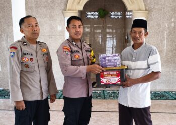 Personel Polri menyerahkan bantuan sosial berupa mushaf Al Quran dan perlengkapan kebersihan Foto LINES Banyuwangi