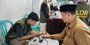 Siswa SMK Bina Sejahtera Mandiri didampingi tenaga kesehatan memeriksa kadar gula darah warga saat layanan kesehatan gratis yang digelar DPD LDII Banyuwangi bersama FKKI Minggu 197 Foto LINES Banyuwangi