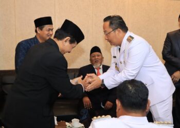 Ketua DPD LDII Gresik Khusnul Hamidi (kiri) berjabat tangan dengan Wakil Bupati Gresik Asluchul Alif usai menghadiri rangkaian peringatan HUT ke-81 Kemerdekaan RI di Kabupaten Gresik, Senin (17/8/2026). Foto: LINES Gresik