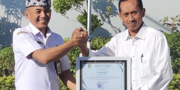 Plt Kepala Dinsos PPKB Banyuwangi Setyo Puguh Widodo menyerahkan sertifikat penghargaan kepada Siswandi di halaman Kantor Dinsos PPKB Banyuwangi Rabu 1282026 Foto LINES Banyuwangi