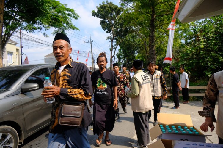 Relawan LDII membagikan air mineral kepada peserta Muktamar Ke 35 NU di sepanjang jalan menuju Pondok Pesantren Bahrul Ulum Tambakberas Jombang Kamis 2782026 Foto LINES Jombang