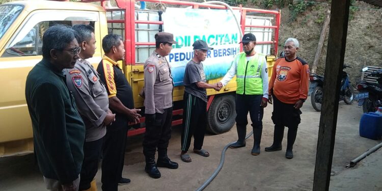 PCLDIITulakansalurkanbantuanairbersih | LDII JAWA TIMUR Ketua PC LDII Tulakan Suyoto menyerahkan bantuan air bersih secara simbolis kepada Kepala Dusun Wonokeso Wasito didampingi Senkom dan personel Polsek Tulakan Kamis 8102026 Foto LINES Pacitan